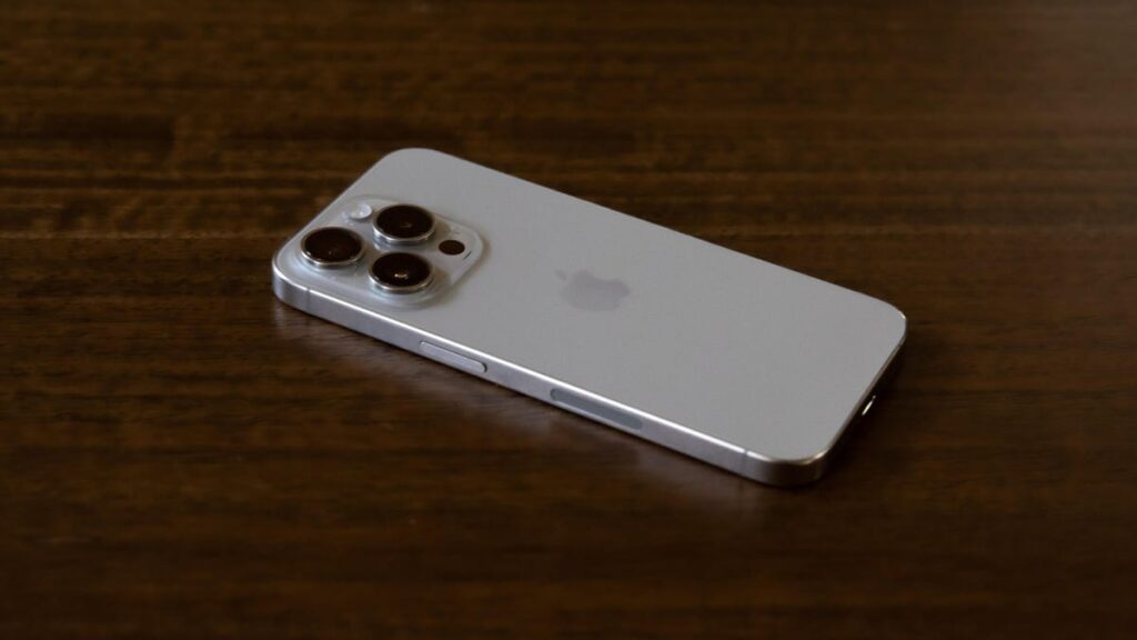 Purple iPhone 14 Pro face down on a red patterned pillow