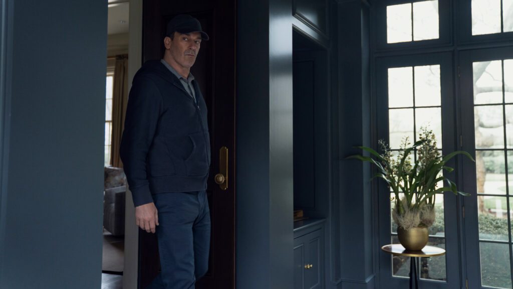 A man wearing a baseball cap standing in a room in Your Friends &amp; Neighbors