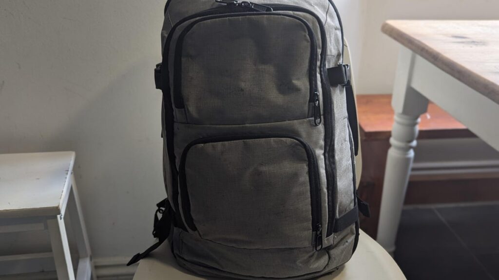 I’m a Travel Writer and My Go-To Travel Backpack Costs Less Than $30 Grey backpack on chair