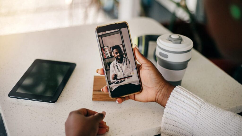 A photo of a woman holding a phone and watching a video message from a man