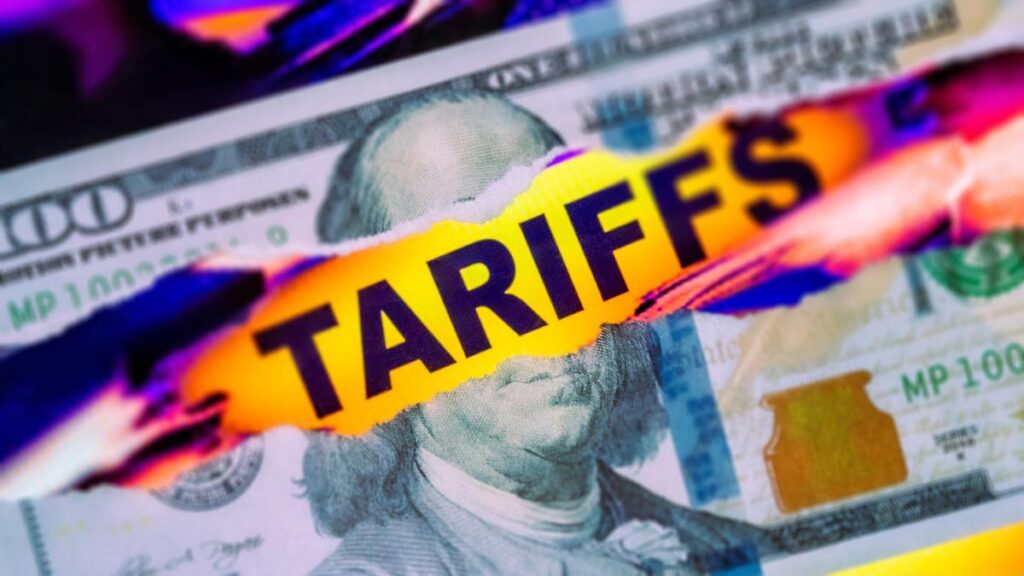 The word "tariffs" appears in a gash through a $100 bill
