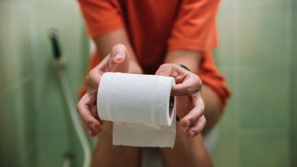 A person sitting on a toilet