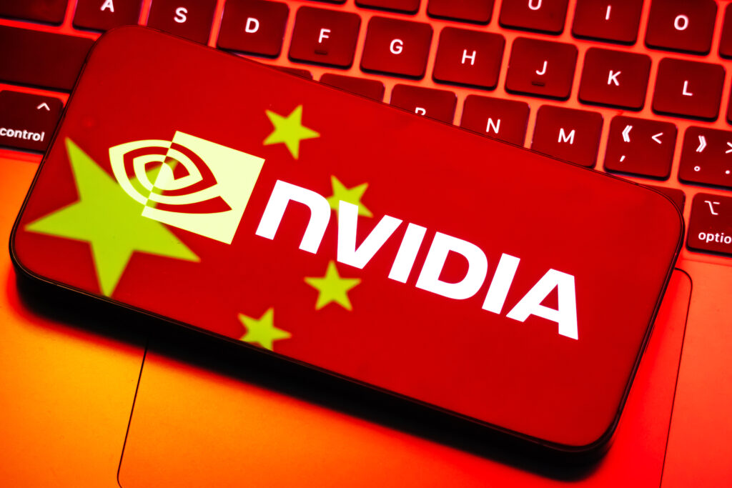 CHONGQING, CHINA - JULY 17: In this photo illustration, the logo of Nvidia Corporation (NASDAQ: NVDA) is displayed on a smartphone screen, with the reflection of the Chinese national flag from a computer screen visible on the device, placed on a red-lit keyboard, on July 17, 2025 in Chongqing, China. (Photo illustration by Cheng Xin/Getty Images)