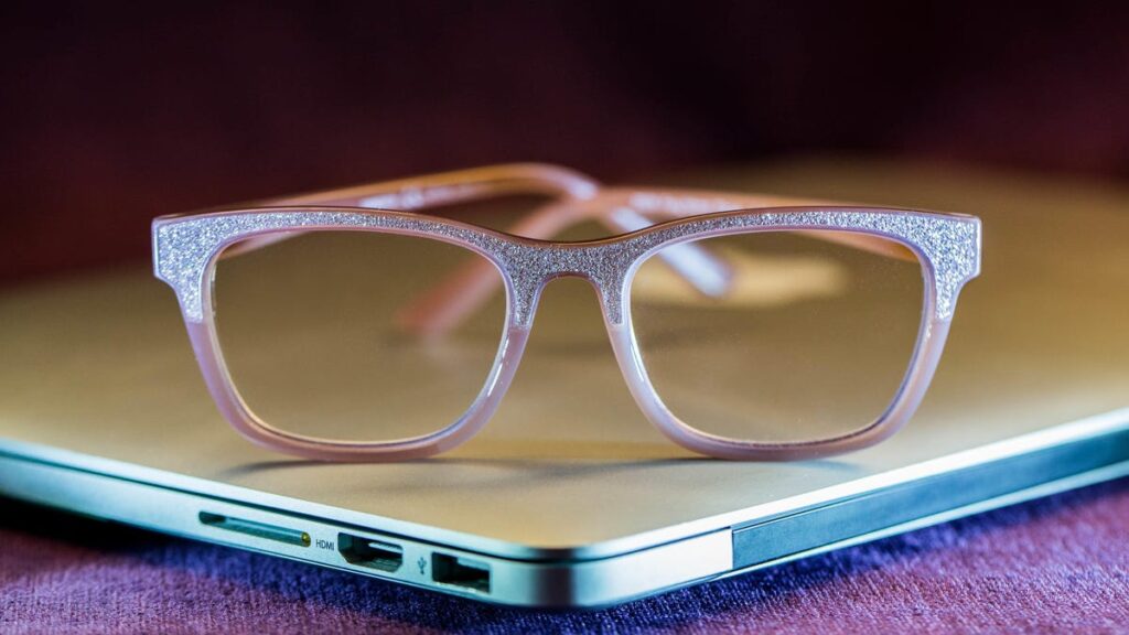 Pair of blue light blocking glasses in front of a screen