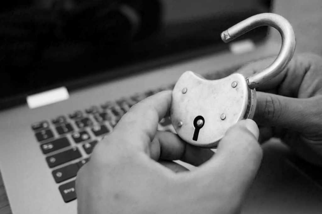 Everyone should know which passwords suck. Do you? adult hands holding an open padlock in front of a laptop
