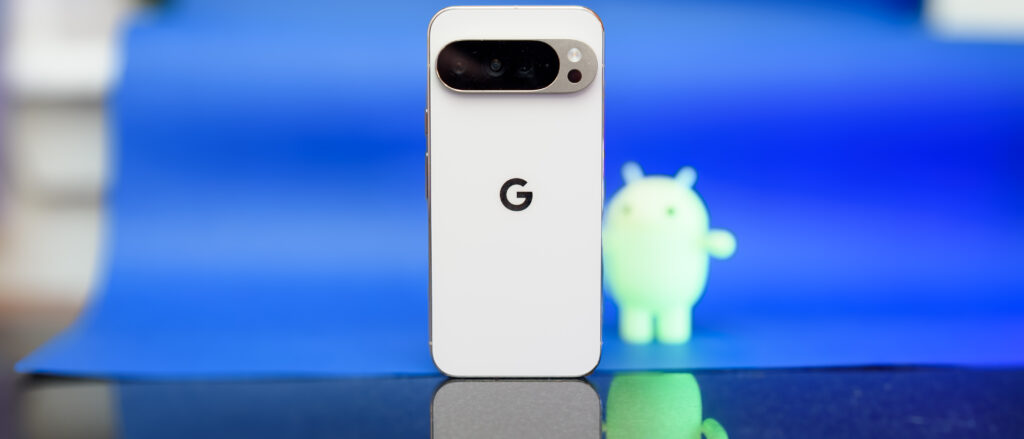 Google Pixel 10 Pro XL in Porcelain against a blue background with a green neon Android figurine in the background