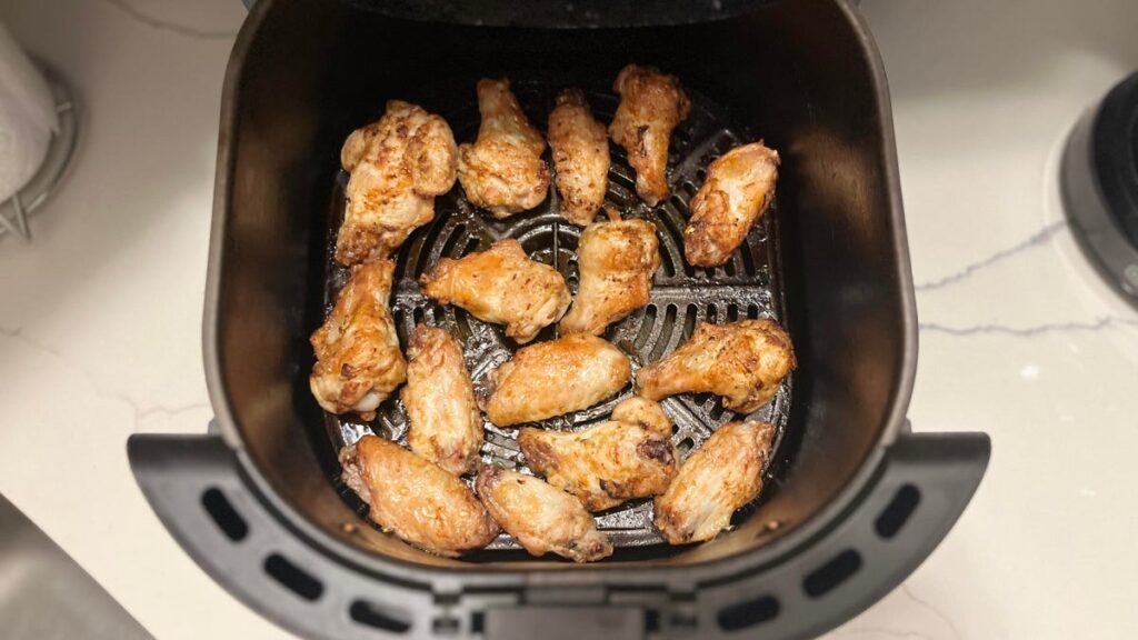 cooked chicken wings in a black air fryer