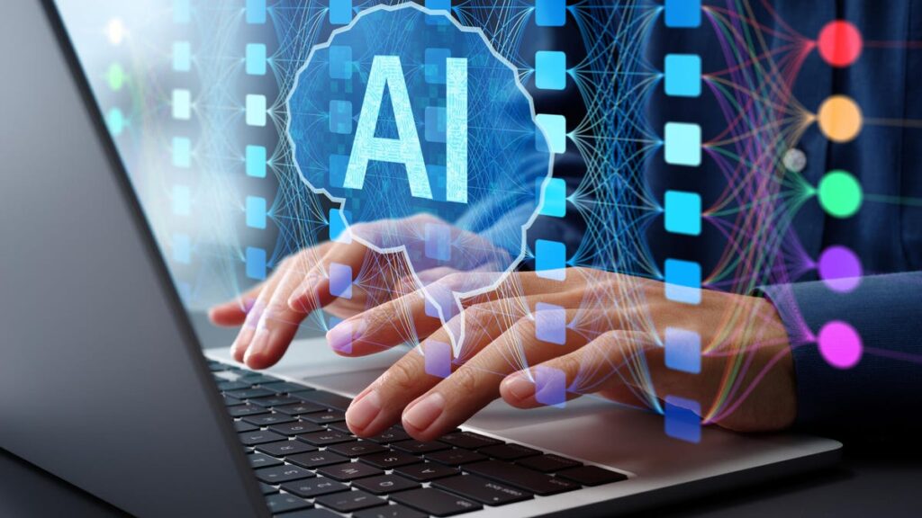 two hands typing on a laptop while a holograph of a brain while inside the brain the letters AI are feeding into it.