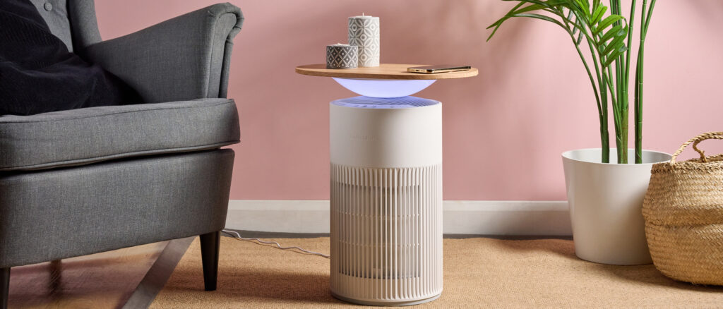 SwitchBot Air Purifier Table review: an efficient air purifier with many talents The SwitchBot Air Purifier Table is pictured in a pink living room. The ambient light below the tabletop is lit up blue.