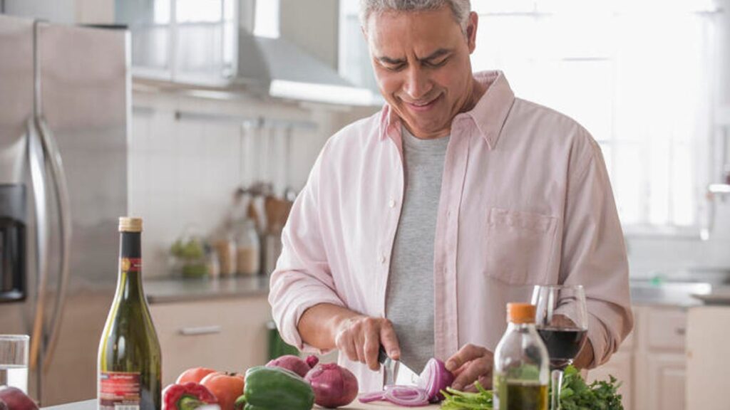 Man cutting up an onion while preparing for dinner