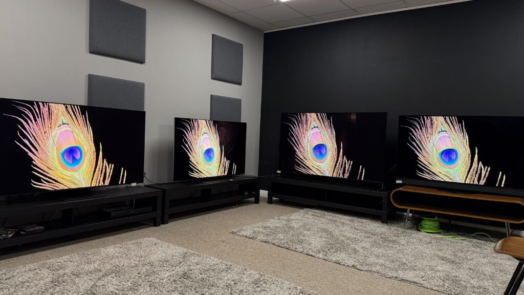 Samsung S95F (far left) LG G5 (middle left) Sony Bravia 8 II (middle rigjt) Panasonic Z95B (far right) OLED TVs all displaying a peacock feather against a black background on screen