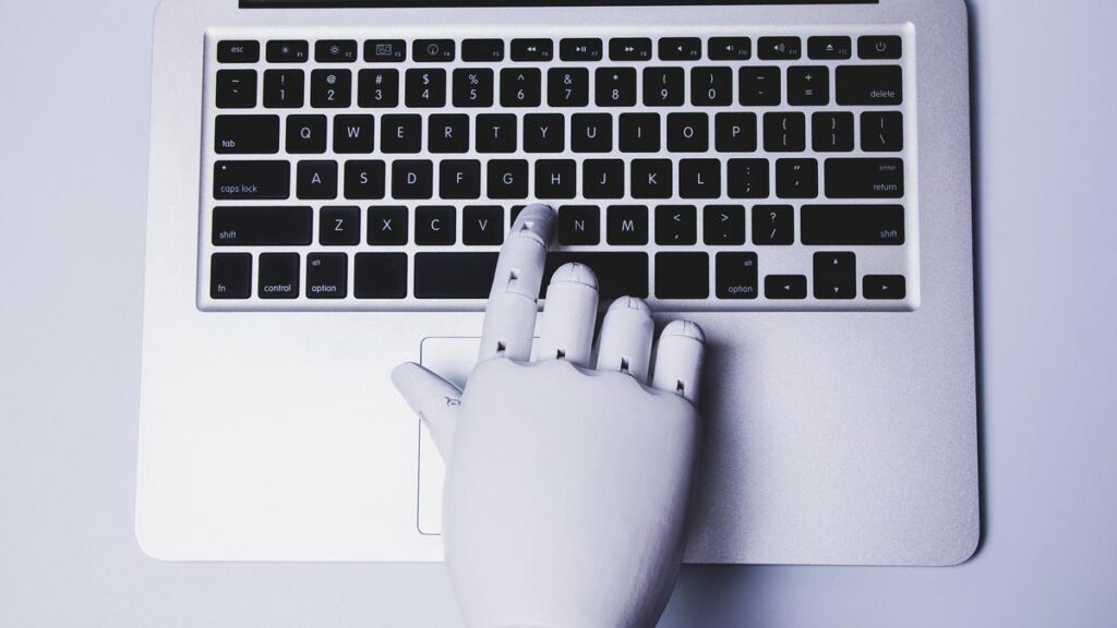 AI Can Probably Do Some of Your Work Tasks. That Doesn’t Mean It Can Do Your Job A robot hand presses a button on a laptop.