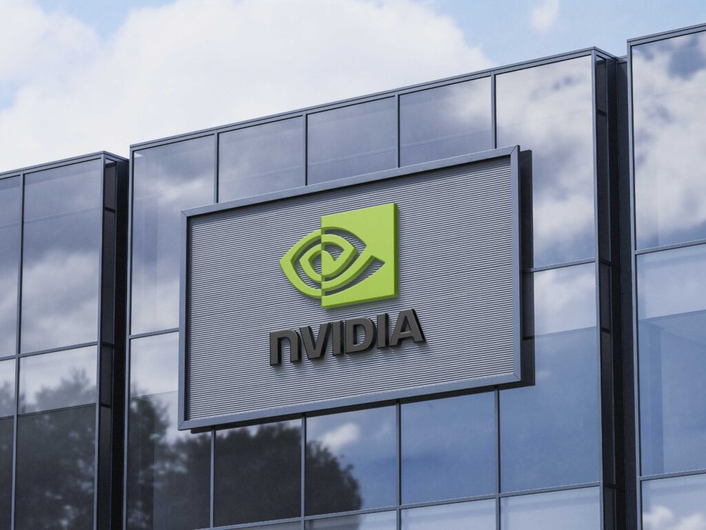 NVIDIA corporate building featuring bold 3D red NVIDIA logo under bright blue sky, symbolizing innovation and electric vehicle dominance in the global stock market