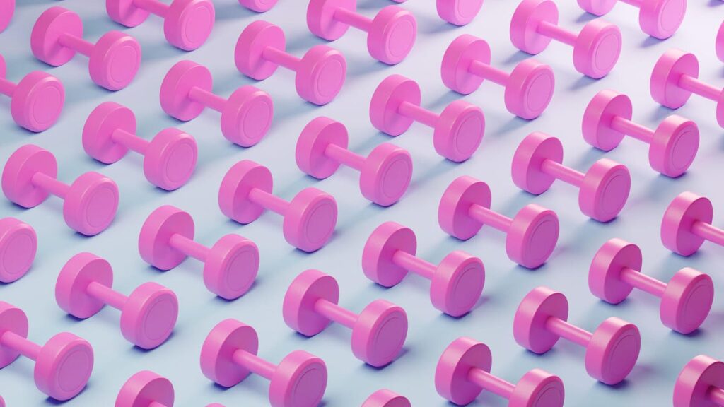 An image showing a series of pink dumbells laid out on a white background (gettyimages-1886169763)