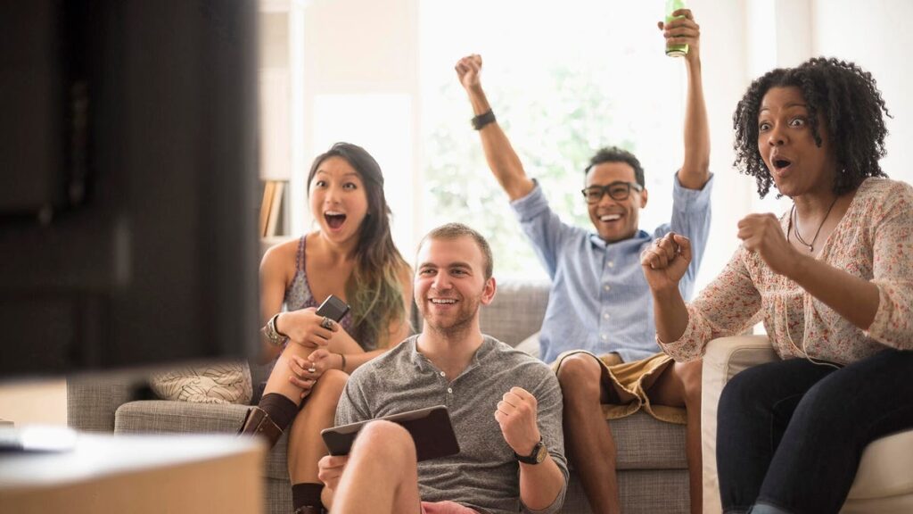 How to Get Your TV Ready for Football Season A group of people in a living room facing a TV.