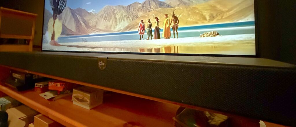 Klipsch Flexus Core 300 soundbar on stand with TV in background