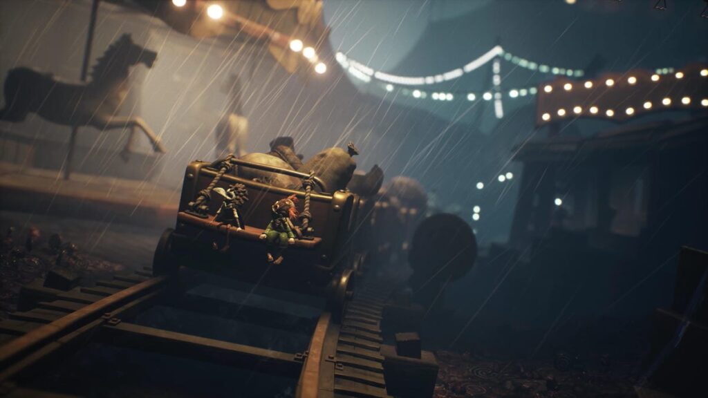 Little Nightmares 3 Hands-On: a Creepy Co-Op Game Arriving Just in Time for Halloween Two small figures, the player characters, sit on the back of a railcar moving through a carnival setting.