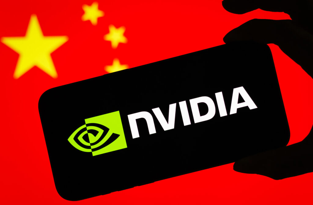 NVIDIA faces antitrust investigation in China CHONGQING, CHINA - JULY 17: In this photo illustration, a smartphone displaying the logo of Nvidia Corporation (NASDAQ: NVDA), a leading American semiconductor and artificial intelligence company, is held in front of a screen showing the national flag of China on July 17, 2025 in Chongqing, China. (Photo illustration by Cheng Xin/Getty Images)