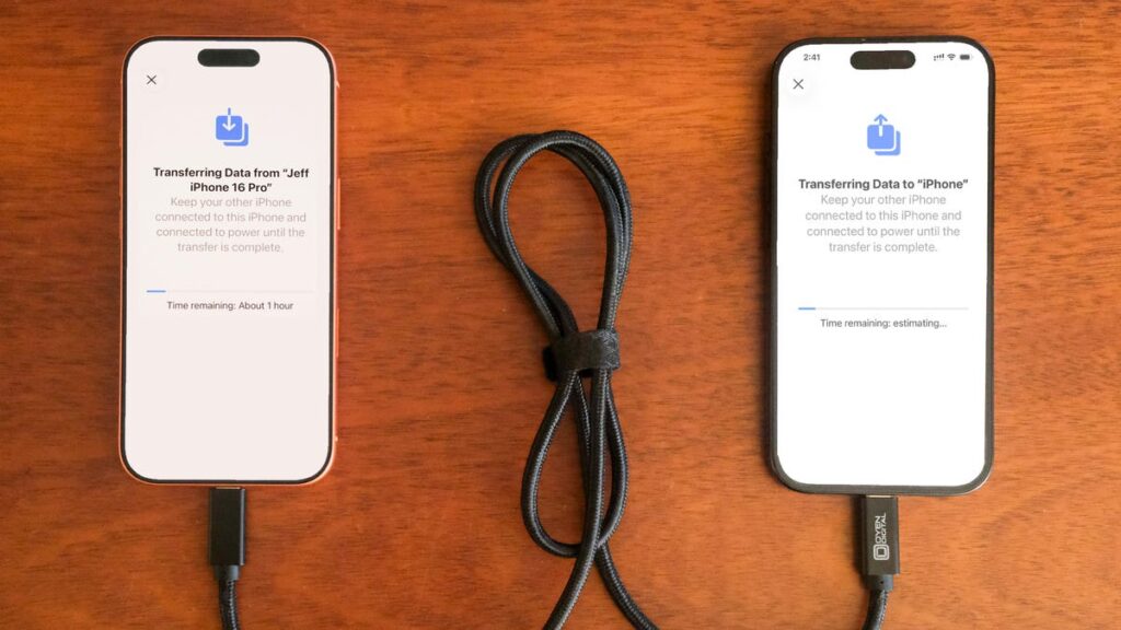 Two iPhones connected by a cable.
