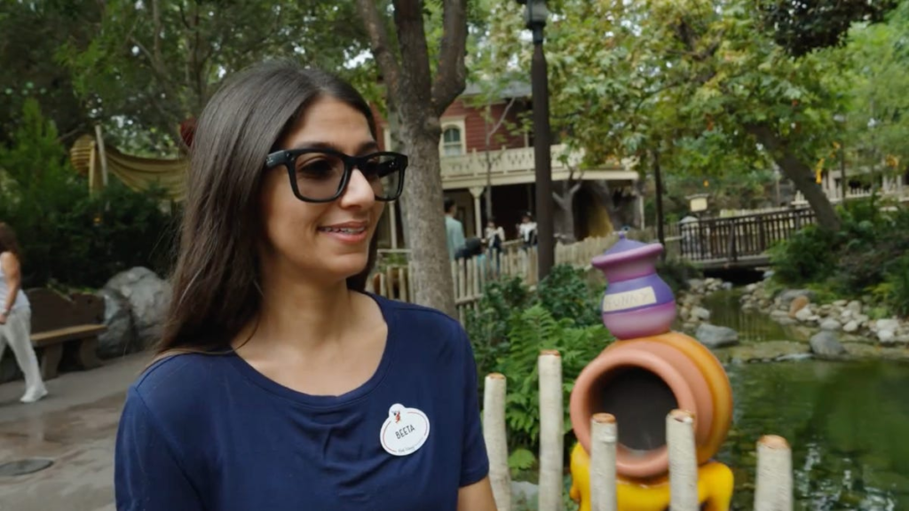An image showing a Disney Imagineer wearing Meta's Ray-Ban smart glasses while walking around Disneyland