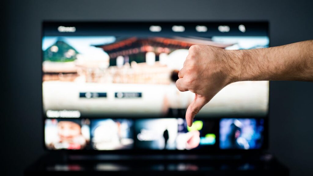 An image of a thumbs down in front of a TV