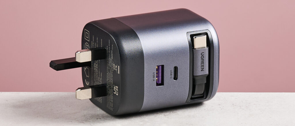 UGreen Nexode 65W Charger with Retractable USB-C Cable review: an ultra-convenient all-in-one charging hub UGreen Nexode 65W Charger with Retractable USB-C Cable on its side against pink background