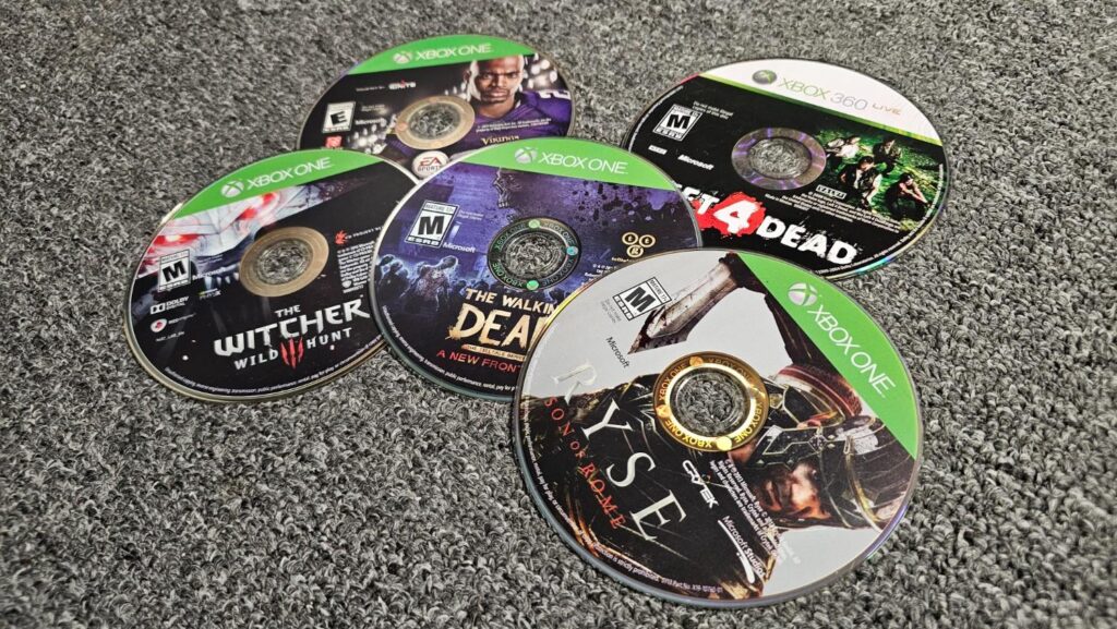 Photo of physical discs Rye, Witcher 3, Left 4 Dead, Madden 25, and The Walking Dead