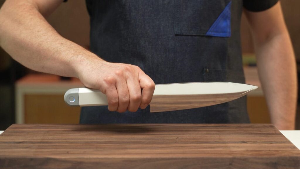 A c-200 knife held over a cutting board.