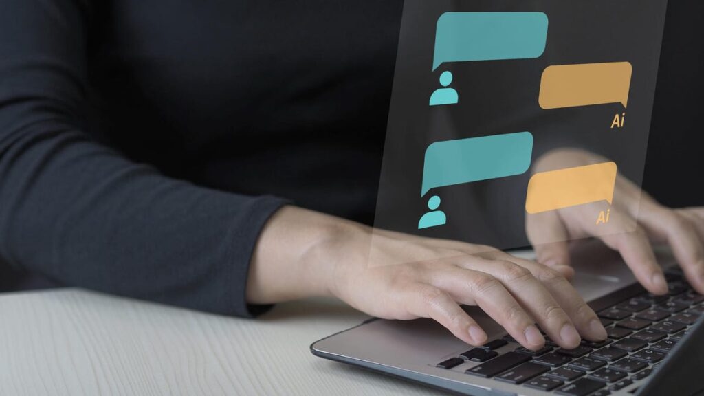 AI Companions Use These 6 Tactics to Keep You Chatting A person's hands type on a laptop keyboard with chat bubbles for a conversation with an AI superimposed above.