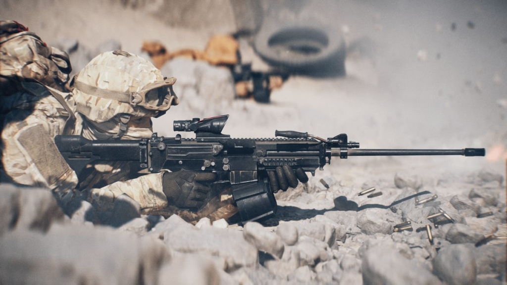 Desert machine gunner lies down flat on the ground with his LMG.