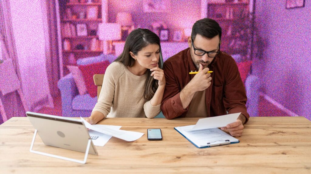 Young couple looking at bills sitting at kitchen table
