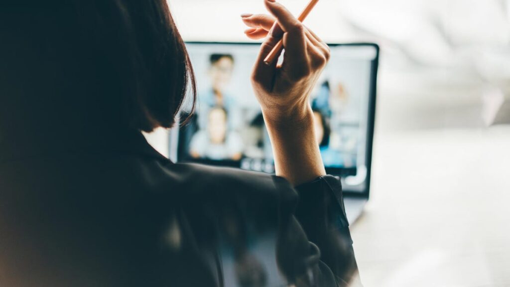 A photo of a woman taking a video call on her laptop, with the photo taken from the back of her head (gettyimages-2154965254)