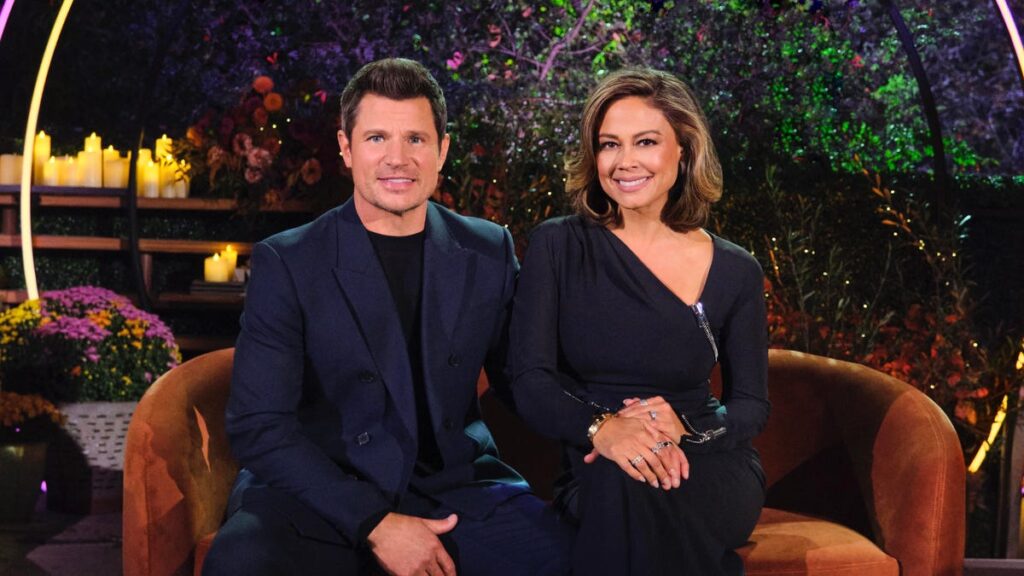 A man and woman sitting on an orange couch.