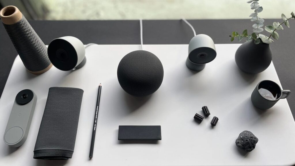 Google Home cameras, doorbell and speaker on a white table.