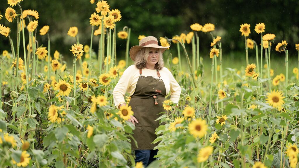 What are the release dates of Murdaugh: Death in the Family episodes on Hulu and Disney+? Patricia Arquette standing in a sunflower field in Murdaugh: Death in the Family
